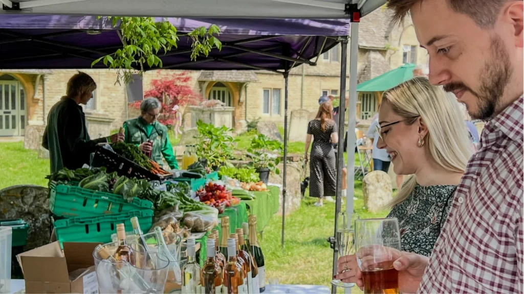 Visitors tasting produce at a stall in the churchyard