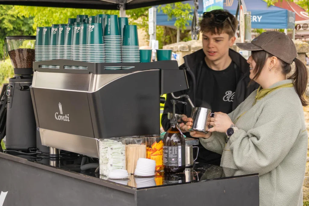 Baristas serving coffee from an espresso machine at the festival