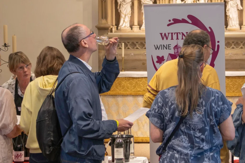 Visitors sampling wine at the Witney wine tasting stand inside St Mary’s